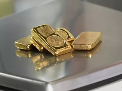 A gold jeweller weighs gold bars at a shop in Bangkok, Thailand, Monday, March 2, 2026. (AP Photo/Sakchai Lalit)