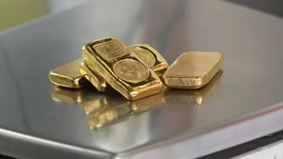 A gold jeweller weighs gold bars at a shop in Bangkok, Thailand, Monday, March 2, 2026. (AP Photo/Sakchai Lalit)