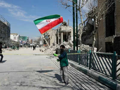 A boy holds an Iranian flag following a strike on a police station, amid the U.S.-Israeli conflict with Iran, in Tehran, Iran, March 4, 2026. Majid Asgaripour/WANA (West Asia News Agency) via REUTERS ATTENTION EDITORS - THIS PICTURE WAS PROVIDED BY A THIRD PARTY / Foto: Majid Asgaripour
