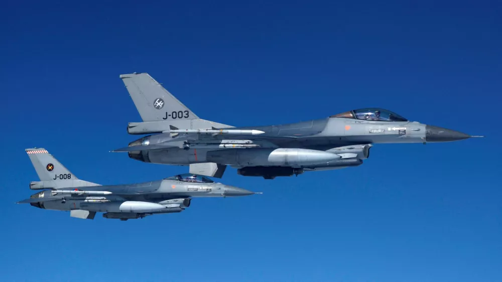 FILE PHOTO: Netherlands' Air Force F-16 fighter jets fly alongside an aircraft simulating aerial interceptions during a media day illustrating how NATO Air Policing safeguards the Allies' airspace in the northern and northeastern region of the Alliance, July 4, 2023. REUTERS/Piroschka van de Wouw/File Photo