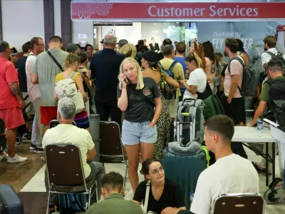 Stranded passengers wait near Emirates Airways customer service office at I Gusti Ngurah Rai International Airport after flights to Doha, Dubai, and Abu Dhabi were cancelled following strikes on Iran launched by the United States and Israel, in Kuta, Bali, Indonesia, March 1, 2026. REUTERS/Johannes Christo