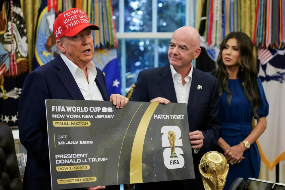 FILE PHOTO: U.S. President Donald Trump and FIFA president Gianni Infantino hold a 2026 FIFA World Cup final match ticket that was presented to President Trump, as the President makes an announcement on the 2026 FIFA World Cup, while U.S. Homeland Security Secretary Kristi Noem stands, in the Oval Office at the White House in Washington, D.C., U.S., August 22, 2025. REUTERS/Jonathan Ernst/File Photo / Foto: Jonathan Ernst