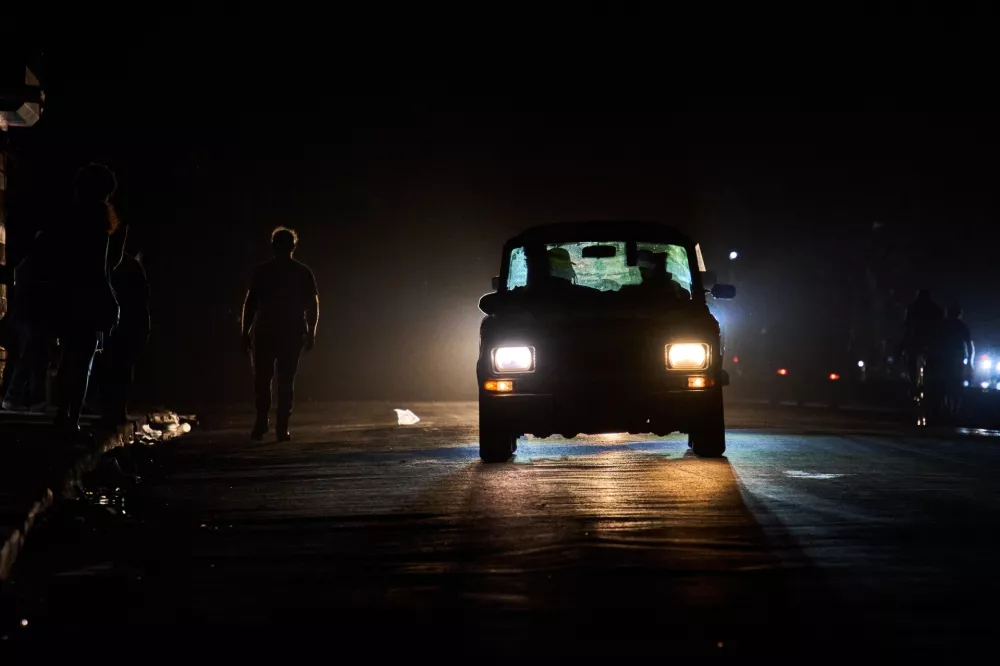 A vehicle drives down a street during a blackout in Havana, Wednesday, March 4, 2026. (AP Photo/Ramon Espinosa)