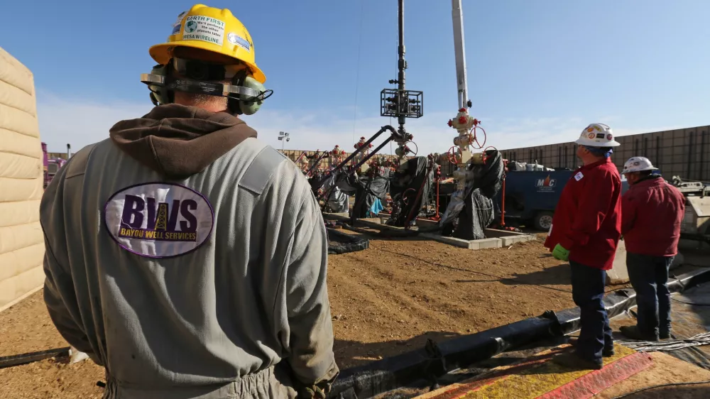 In this March 25, 2014 photo, workers keep an eye on well heads during a hydraulic fracturing operation at an Encana Corp. oil well, near Mead, Colo. The first experimental use of hydraulic fracturing was in 1947, and more than 1 million U.S. oil and oil wells have been fracked since, according to the American Petroleum Institute. The National Petroleum Council estimates that up to 80 percent of natural oil wells drilled in the next decade will require hydraulic fracturing. (AP Photo/Brennan Linsley)