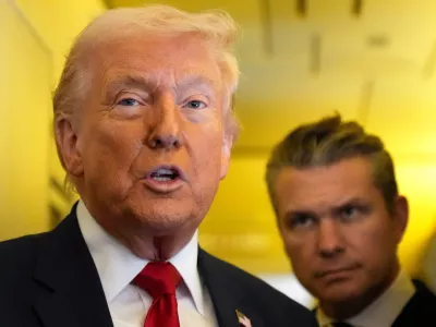 President Donald Trump speaks to reporters as Defense Secretary Pete Hegseth listens while traveling aboard Air Force One en route from Dover Air Force Base, Del., to Miami, Saturday, March 7, 2026. (AP Photo/Mark Schiefelbein)