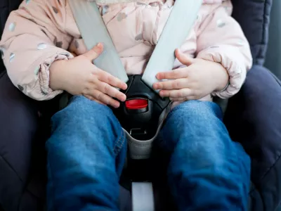 Hands of a little girl lie on the seat belt buckle of a child seat. Close-up,Image: 538187485, License: Royalty-free, Restrictions:, Model Release: yes