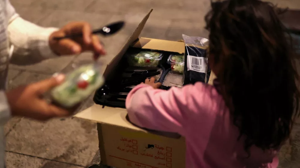 A girl gets food from a box, as her family was displaced following an escalation between Hezbollah and Israel amid the U.S.-Israeli conflict with Iran, in Beirut, Lebanon, March 10, 2026. REUTERS/Claudia Greco