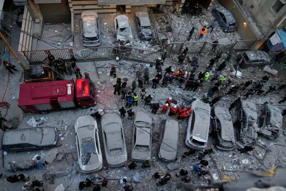 Rescue workers gather at the site where Israeli airstrikes hit apartments in Beirut, Lebanon, Wednesday, March 11, 2026. (AP Photo/Hussein Malla)
