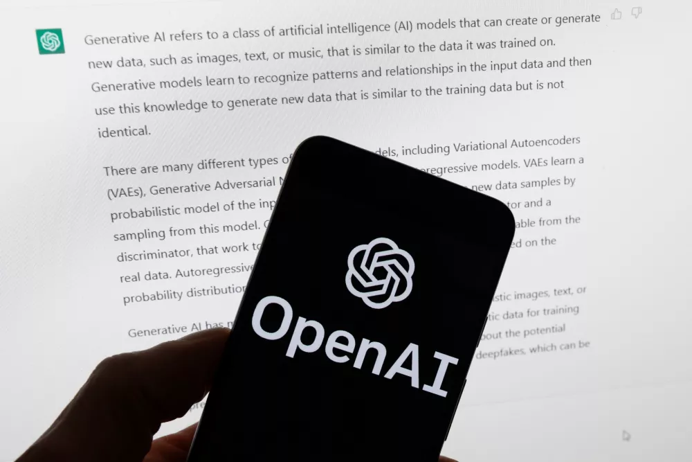 FILE - The OpenAI logo is displayed on a mobile phone in front of a computer screen with output from ChatGPT, March 21, 2023, in Boston. (AP Photo/Michael Dwyer, File)