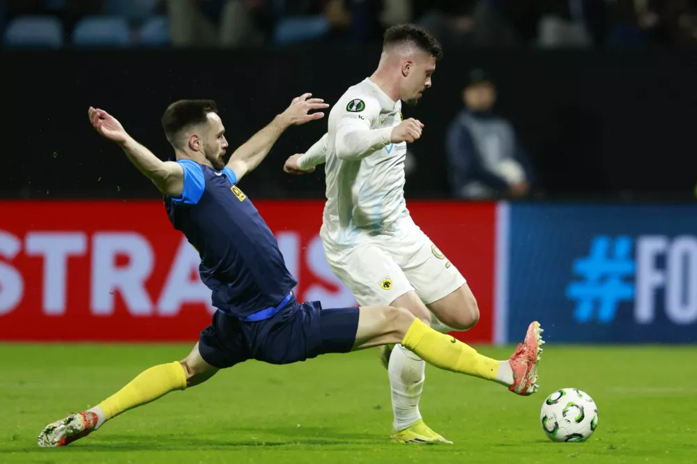 Soccer Football - UEFA Conference League - Round of 16 - First Leg - Celje v AEK Athens - Z'dezele Stadium, Celje, Slovenia - March 12, 2026 AEK Athens' Luka Jovic in action with Celje's Darko Hrka REUTERS/Borut Zivulovic