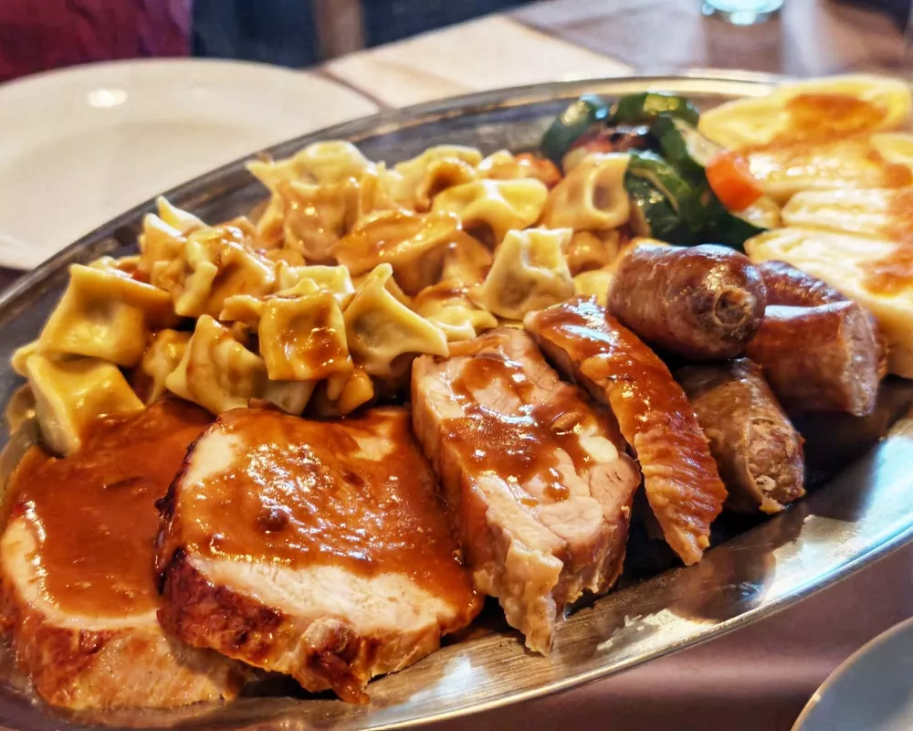 Mesnine v treh oblikah v spremstvu prilog, tudi nagrajenih idrijskih žlikrofov / Foto: Miha First