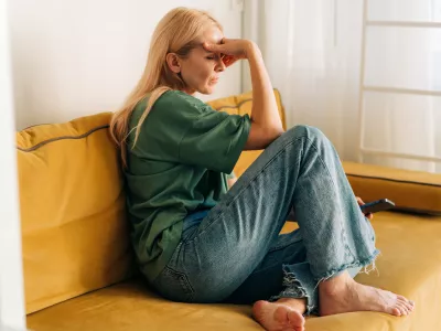 Depressed sad middle aged woman sitting on sofa at home. / Foto: Ilona Titova
