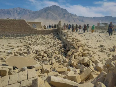 People stand near a house damaged in what the Taliban said was a Pakistani air strike on the outskirts of Kabul, Afghanistan, March 13, 2026. Picture taken with a mobile phone. REUTERS/Sayed Hassib
