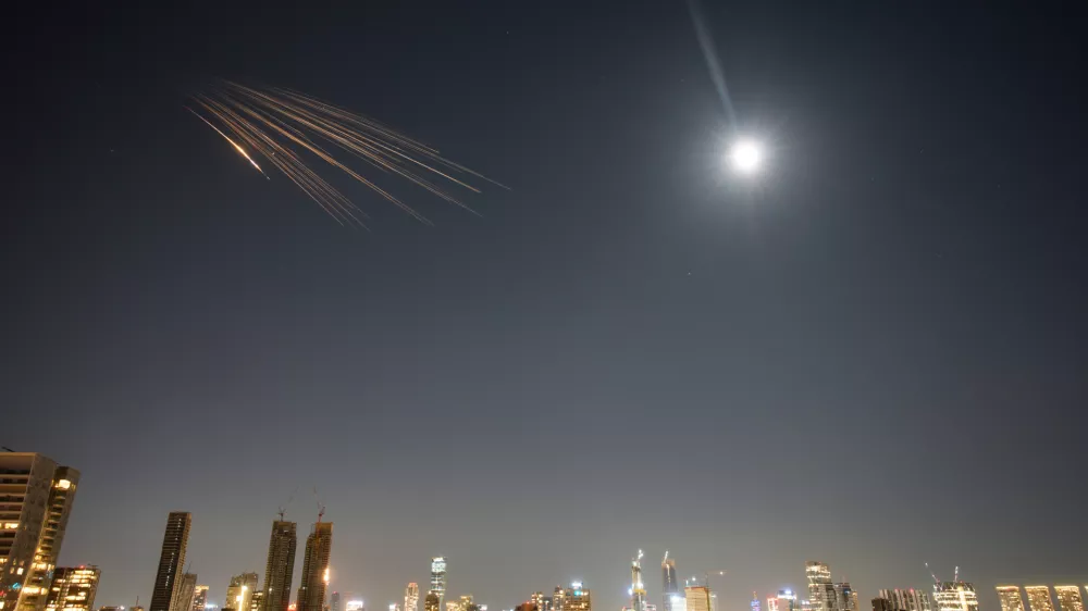 Missiles launched from Iran streak across the sky over central Israel, Thursday, March 5, 2026. (AP Photo/Ohad Zwigenberg)