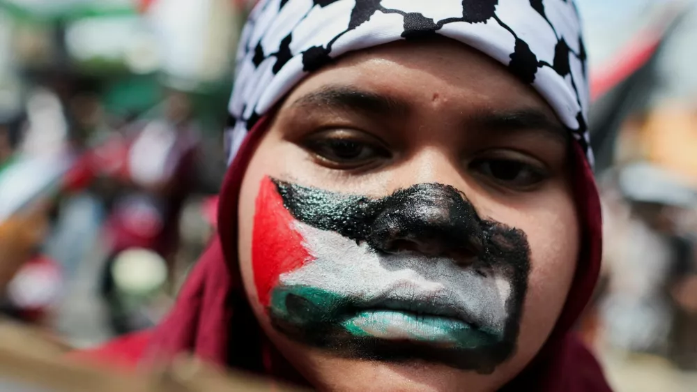 A pro-Palestine supporter paints her face with the Palestinian flag during a rally to the U.S. Embassy to mark al-Quds (Jerusalem) Day, initiated by Ruhollah Khomeini, leader of Iran's 1979 Islamic Revolution, and observed on the last Friday of the Muslim fasting month of Ramadan to show solidarity with Palestinians and opposition to Zionism, in Kuala Lumpur, Malaysia, March 13, 2026. REUTERS/Hasnoor Hussain
