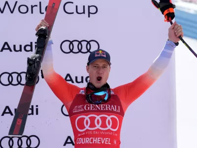 Switzerland's Marco Odermatt celebrates on the podium after taking third place in an alpine ski, men's World Cup downhill race, in Courchevel, France, Friday, March 13, 2026. (AP Photo/Giovanni Auletta)