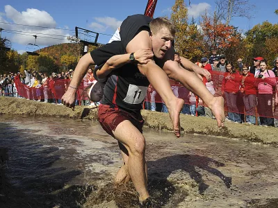 Reeder Famnestock with Sarah Silverberg of Dover, N.H. exit the bog on the race course in the annual North American Wife-Carrying Competition held at the Sunday River Ski Resort in Newry, Maine, on Saturday, Oct. 11, 2008. (AP Photo/The Sun-Journal, Jose Leiva)