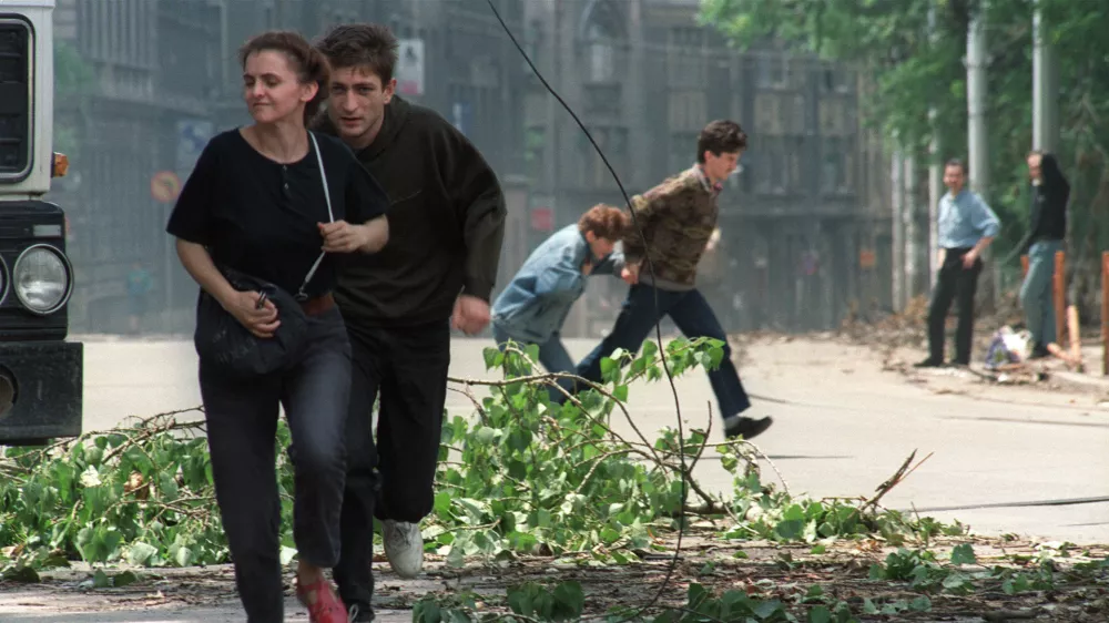 (FILES) Sarajevo residents run through an intersection known for sniper activity after a shell fell in the center of the city on June 20, 1992. Milan's prosecutor office has opened an investigation into "weekend snipers," many of them Italians, who during the siege of Sarajevo in the early 1990s allegedly paid the Serbian army to shoot civilians, according to the Italian press and the former mayor of Sarajevo. These "war tourists," mostly wealthy, gun-loving, far-right sympathizers, gathered in Trieste, northern Italy, before being taken to the hills surrounding Sarajevo, according to La Repubblica newspaper.,Image: 1052225522, License: Rights-managed, Restrictions:, Model Release: no