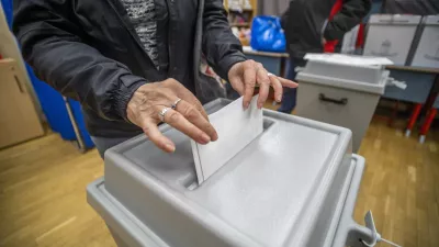 A woman casts her vote at a local polling station during the general election and national referendum on the child protection law in Budapest, Hungary, Sunday, April 3, 2022. (Gyorgy Varga/MTI via AP)