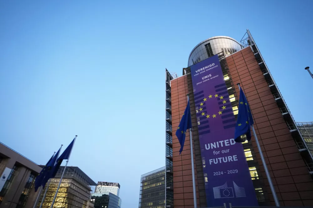 European Union flags flap in the wind outside of EU headquarters during the EU summit in Brussels, Thursday, March 19, 2026. (AP Photo/Virginia Mayo)