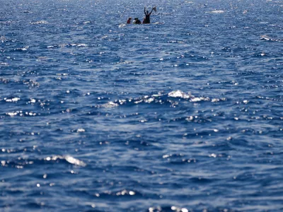 FILE-- Migrants from Syria and Libya in a wooden boat call for help as they are assisted by Spanish NGO Open Arms during a rescue operation inside Malta's SAR zone south of the Italian island of Lampedusa in the Mediterranean Sea, Wednesday, Aug. 10, 2022. (AP Photo/Francisco Seco)