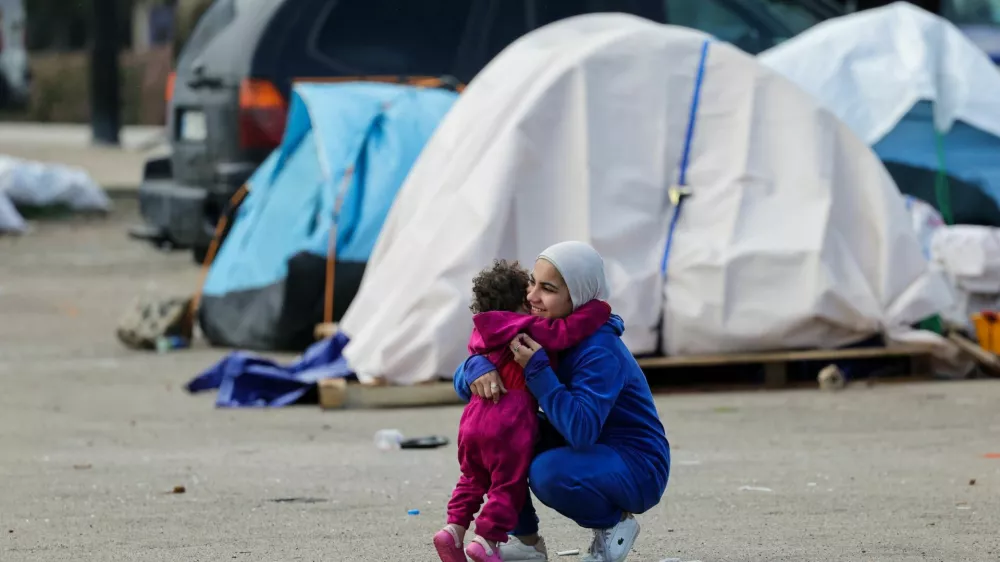 A woman hugs a child near shelters of displaced people on the day Muslim worshippers attend Eid al-Fitr prayers to mark the end of the holy fasting month of Ramadan, following an escalation between Hezbollah and Israel amid the U.S.-Israeli conflict with Iran, in Beirut, Lebanon, March 20, 2026. REUTERS/Yara Nardi