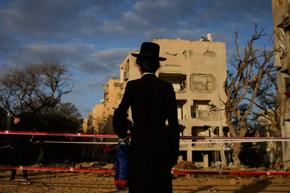People look at residential buildings damaged by an Iranian missile strike in Arad, southern Israel, Sunday, March 22, 2026. (AP Photo/Ohad Zwigenberg)