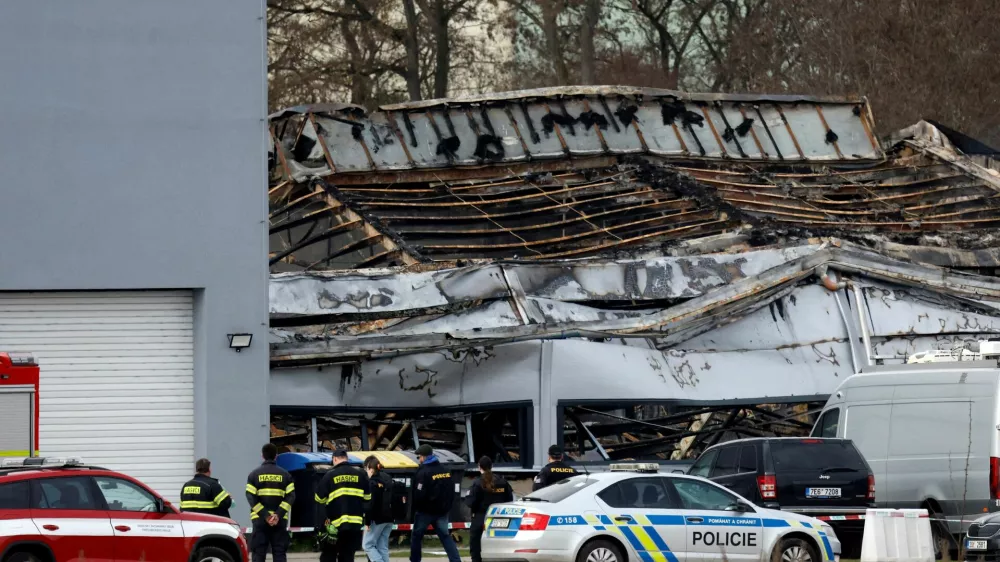 Police officers and a firefighters stand in front of a burned production hall at an industrial area in Pardubice, Czech Republic, March 20, 2026. REUTERS/David W Cerny   TPX IMAGES OF THE DAY