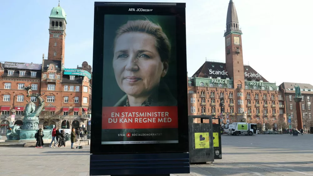 People walk near an election advertisement for Mette Frederiksen, Denmark's Prime Minister and leader of the Social Democrats party ahead of parliamentary elections in Copenhagen, Denmark, March 23, 2026. REUTERS/Leonhard Foeger