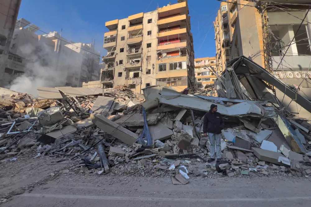 A man stands on the rubbles of a destroyed building that was hit by an Israeli airstrike in Dahiyeh, Beirut's southern suburbs, Lebanon, Tuesday, March 24, 2026. (AP Photo/Hussein Malla)