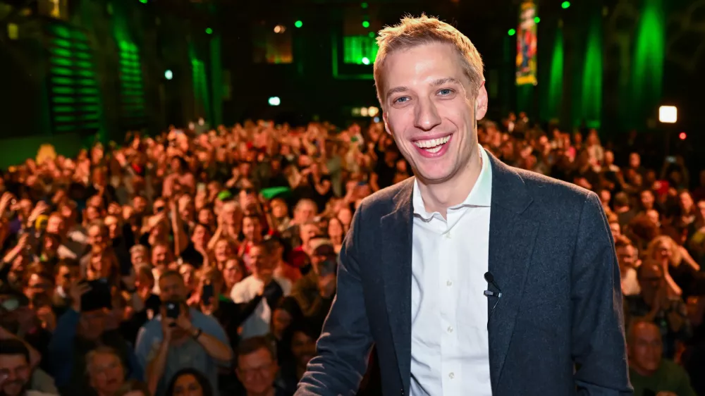 Dominik Krause, right, top candidate of the Green party, on stage at the Green Party election party after the run-off election for the office of Lord Mayor in the Bavarian capital of Munich, Germany, Sunday, March 22, 2026. (Sven Hoppe/dpa via AP)
