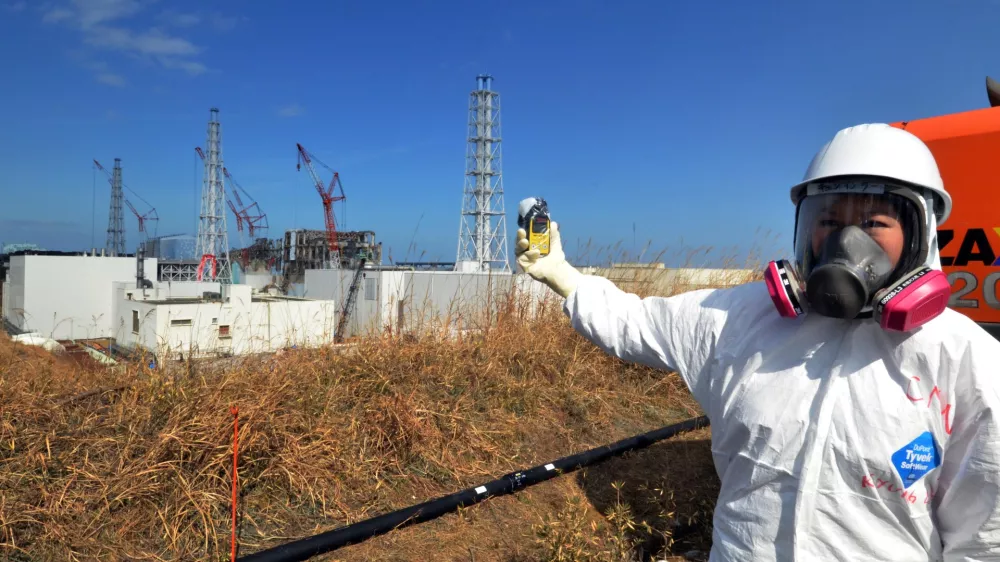 A journalist checks radiation level with her dosimeter near stricken Fukushima Dai-ichi nuclear power plant of Tokyo Electric Power Co., during a press tour led by TEPCO officials, in Okuma town, Fukushima prefecture, northeastern Japan Tuesday, Feb. 28, 2012. Japan next month marks one year since the March 11 tsunami and earthquake, which triggered the worst nuclear accident since Chernobyl in 1986. (AP Photo/Yoshikazu Tsuno, Pool)