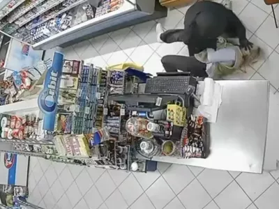 Nesojeni ropar je prodajalko vrgel po tleh in jo tepel, ona pa se je krčevito držala njegovega orožja. 