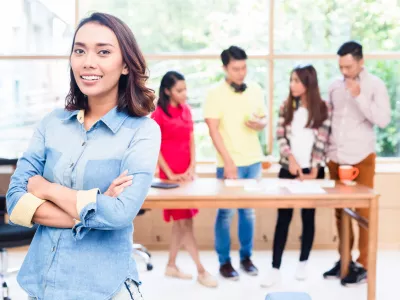 Portrait of young Asian woman looking at camera with self-confidence and determination as member of a young creative team