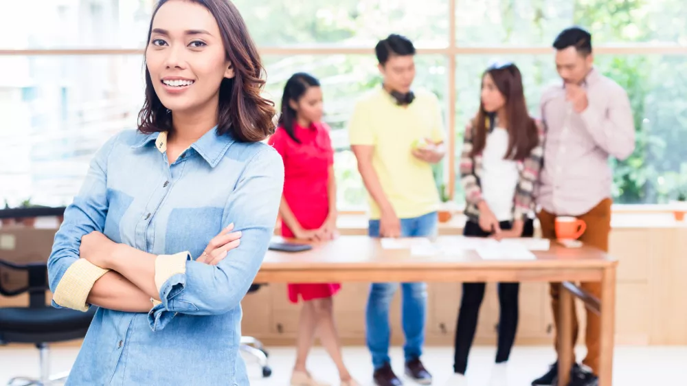 Portrait of young Asian woman looking at camera with self-confidence and determination as member of a young creative team