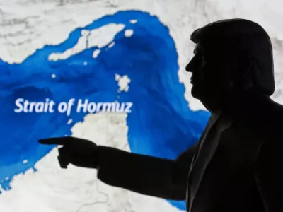 A map showing the Strait of Hormuz and a 3D-printed miniature model depicting U.S. President Donald Trump are seen in this illustration taken March 23, 2026. REUTERS/Dado Ruvic/Illustration