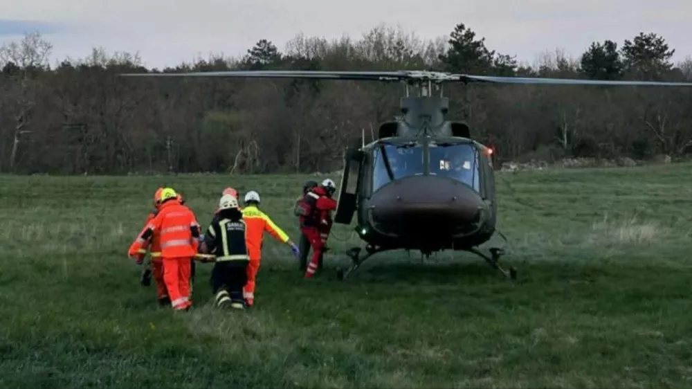 Gasilci iz Komna so mo&scaron;kega odnesli do helikopterja, s katerim so ga odpeljali v bolni&scaron;nico. 