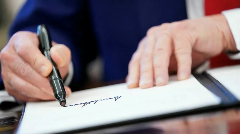 FILE PHOTO: U.S. President Donald Trump writes his signature, as he signs executive orders and proclamations in the Oval Office at the White House in Washington, D.C., U.S., April 9, 2025. REUTERS/Nathan Howard/File Photo/File Photo