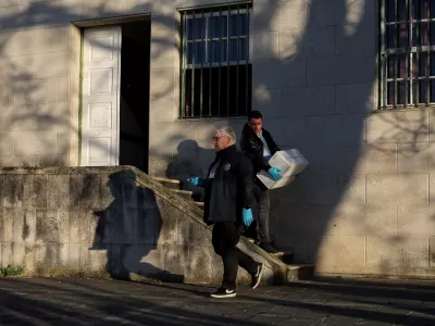 A police investigator carries a box related to the process of a French citizen who is answering before a judge, on the case of two women who were found buried in Braganca, in Vila Nova de Foz Coa courthouse, Portugal, March 26, 2026. REUTERS/Pedro Nunes