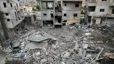 Journalists check the site of a destroyed building that was hit in an Israeli airstrike in the southern port city of Tyre, Lebanon, Thursday, March 26, 2026. (AP Photo/Hussein Malla)