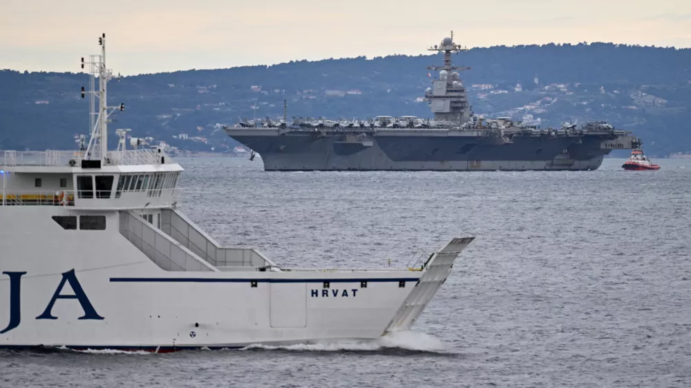A Croatian ferryboat sails by as USS Gerald R. Ford arrives to the port of Split, Croatia, Saturday, March 28, 2026. (AP Photo/Tom Dubravec)