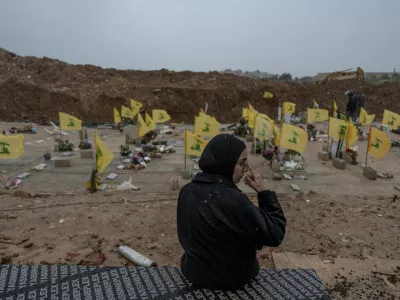 A woman sits in a cemetery before the funeral of Lebanese journalists, Al Manar reporter Ali Shaib, Al Mayadeen reporter Fatima Ftouni and cameraman Mohammed Ftouni, who were killed by a targeted Israeli strike, amid escalating hostilities between Israel and Hezbollah, as the U.S.-Israeli conflict with Iran continues, in Choueifat, Lebanon, March 29, 2026. REUTERS/Manu Brabo   TPX IMAGES OF THE DAY
