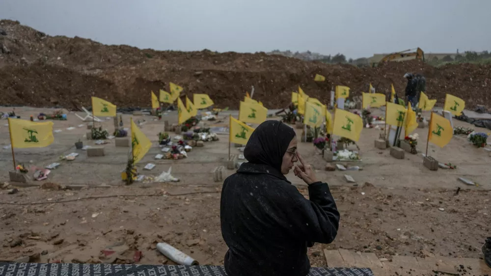A woman sits in a cemetery before the funeral of Lebanese journalists, Al Manar reporter Ali Shaib, Al Mayadeen reporter Fatima Ftouni and cameraman Mohammed Ftouni, who were killed by a targeted Israeli strike, amid escalating hostilities between Israel and Hezbollah, as the U.S.-Israeli conflict with Iran continues, in Choueifat, Lebanon, March 29, 2026. REUTERS/Manu Brabo   TPX IMAGES OF THE DAY