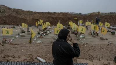 A woman sits in a cemetery before the funeral of Lebanese journalists, Al Manar reporter Ali Shaib, Al Mayadeen reporter Fatima Ftouni and cameraman Mohammed Ftouni, who were killed by a targeted Israeli strike, amid escalating hostilities between Israel and Hezbollah, as the U.S.-Israeli conflict with Iran continues, in Choueifat, Lebanon, March 29, 2026. REUTERS/Manu Brabo   TPX IMAGES OF THE DAY