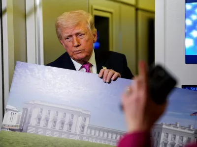 A member of the media raises her hand for a question as U.S. President Donald Trump talks while holding up renderings of the planned White House ballroom, aboard Air Force One en route to Joint Base Andrews, Maryland, U.S., March 29, 2026. REUTERS/Elizabeth Frantz