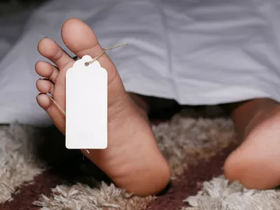 The dead man's body with tag on feet under white cloth in a morgue.,Image: 668558601, License: Royalty-free, Restrictions:, Model Release: no