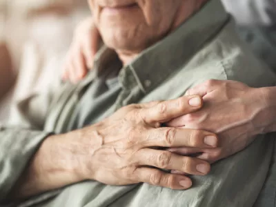 Comforting hand supporting the old man