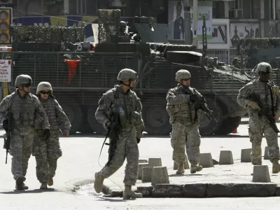 U.S. soldiers from the 172nd Stryker Brigade Combat Team patrol a road in Baghdad in this October 27, 2006 file photo. President George W. Bush will tell skeptical Americans on January 10, 2007 he will send about 21,500 extra U.S. troops to Iraq and admit it was a mistake not to have more forces fighting the unpopular war in the past. REUTERS/Mahmoud Raouf Mahmoud/Files (IRAQ)