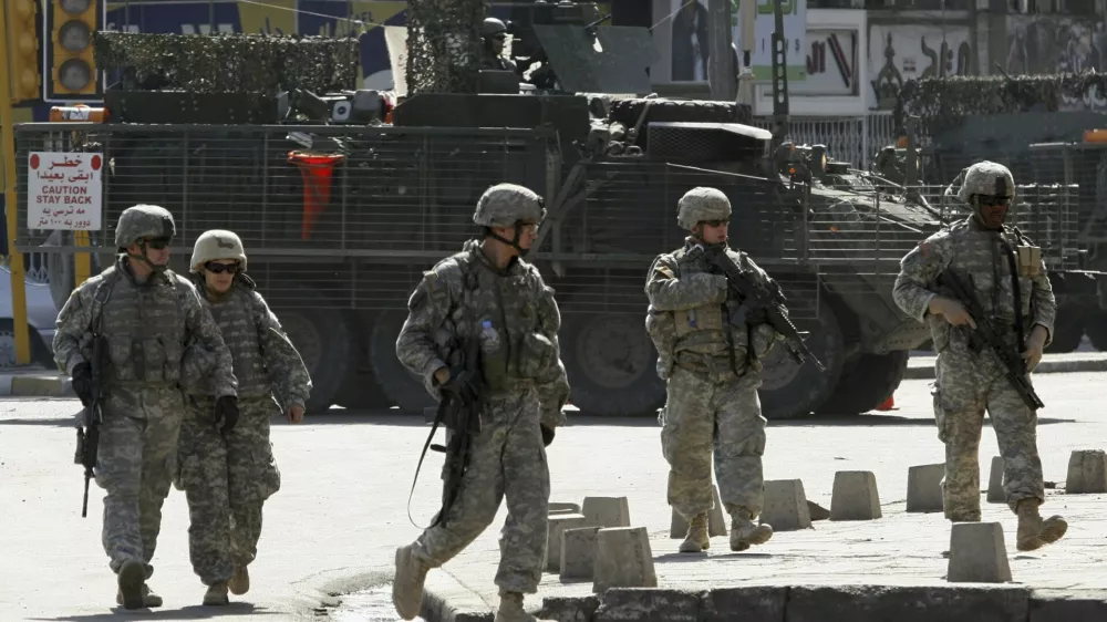 U.S. soldiers from the 172nd Stryker Brigade Combat Team patrol a road in Baghdad in this October 27, 2006 file photo. President George W. Bush will tell skeptical Americans on January 10, 2007 he will send about 21,500 extra U.S. troops to Iraq and admit it was a mistake not to have more forces fighting the unpopular war in the past. REUTERS/Mahmoud Raouf Mahmoud/Files (IRAQ)