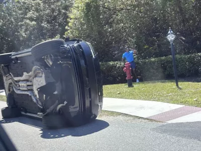 FILE- Golfer Tiger Woods stands by his overturned vehicle in Jupiter Island, Fla., March 27, 2026. (AP Photo/Jason Oteri, File)